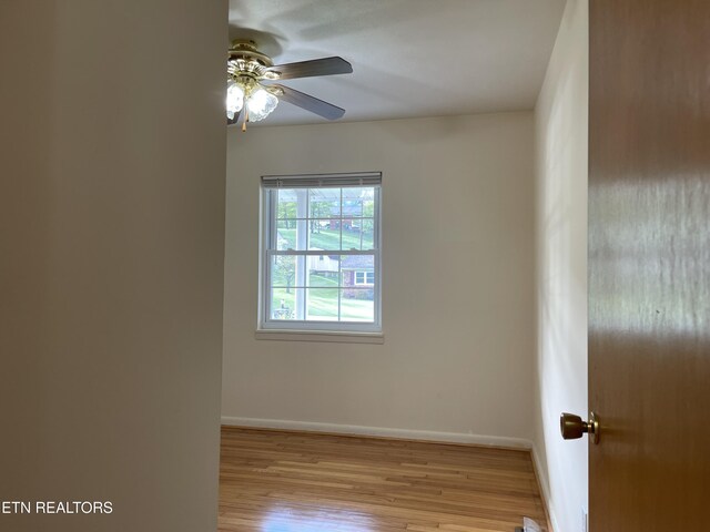 empty room with a ceiling fan, baseboards, and wood finished floors