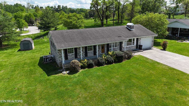 view of front facade featuring stone siding, covered porch, a front yard, a shed, and driveway