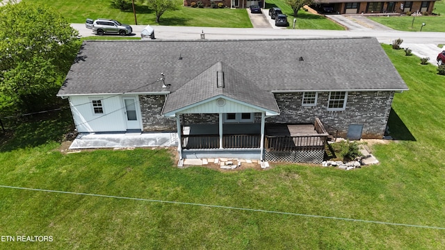 back of house with a sunroom, a yard, and roof with shingles