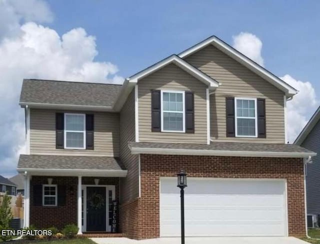 view of front of home with brick siding, driveway, and a garage