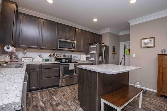 kitchen with stainless steel appliances, a sink, dark wood-style floors, dark brown cabinets, and tasteful backsplash
