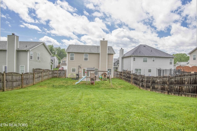 back of property featuring a playground, a residential view, and a chimney