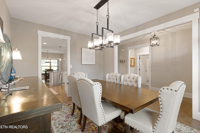 dining room with recessed lighting, wood finished floors, a chandelier, and baseboards
