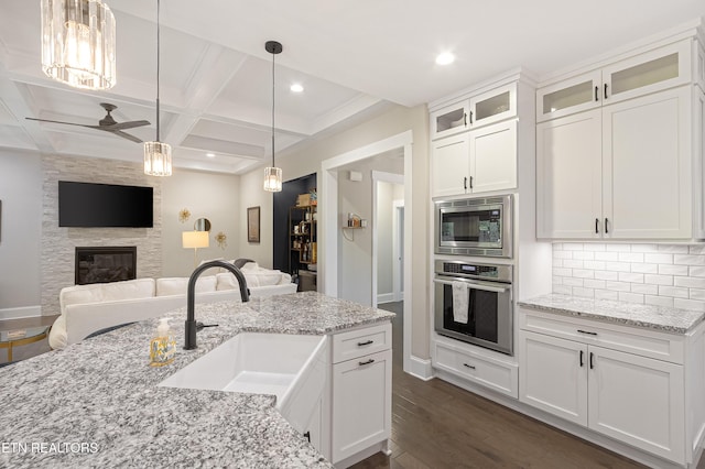 kitchen featuring a sink, dark wood-style flooring, coffered ceiling, a ceiling fan, and appliances with stainless steel finishes