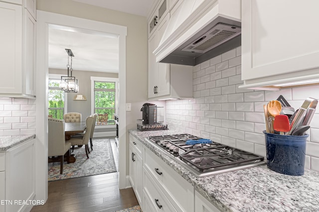 kitchen featuring stainless steel gas cooktop, custom range hood, and white cabinets