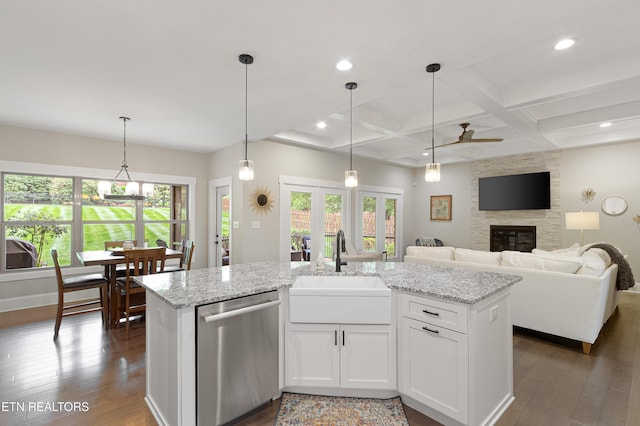 kitchen featuring stainless steel dishwasher, dark wood-style floors, a sink, and a fireplace
