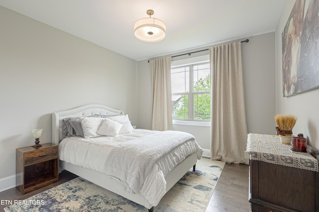 bedroom featuring baseboards and wood finished floors
