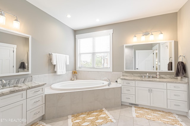 bathroom featuring tile patterned floors, visible vents, a bath, and a sink