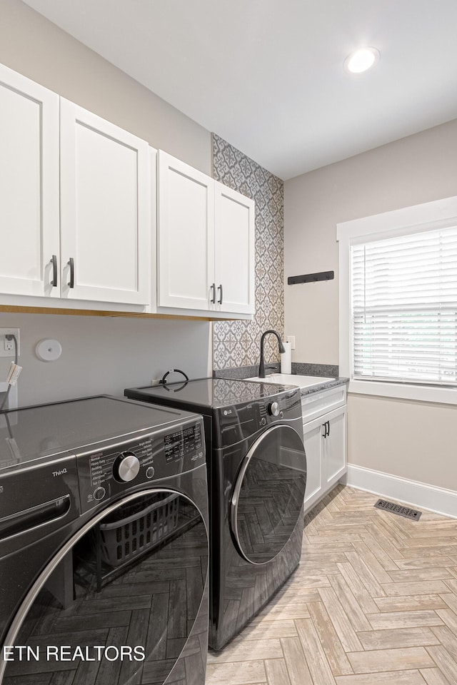 washroom with recessed lighting, a sink, cabinet space, visible vents, and washer and dryer