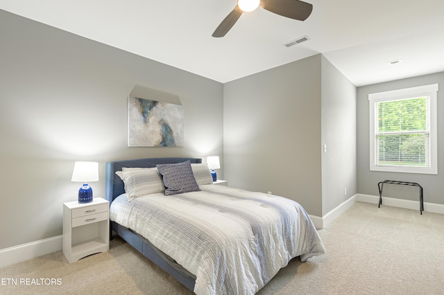 carpeted bedroom with a ceiling fan, visible vents, and baseboards