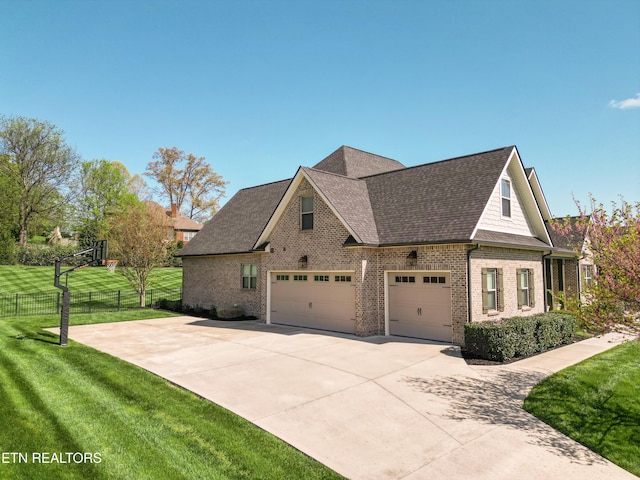 view of side of home featuring a yard, brick siding, fence, a shingled roof, and driveway