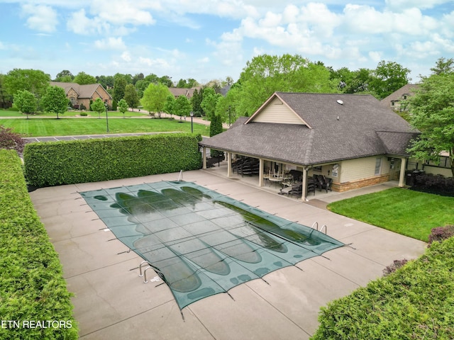 view of swimming pool featuring a lawn, fence, a patio area, and a fenced in pool