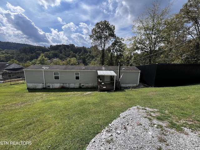 back of property featuring crawl space and a yard