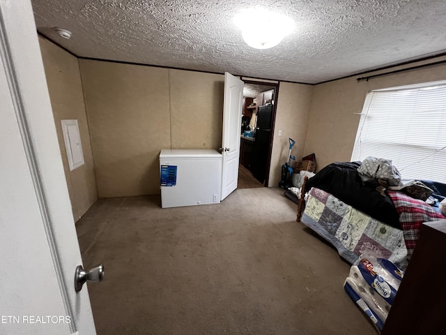 carpeted bedroom featuring a textured ceiling, refrigerator, and freestanding refrigerator