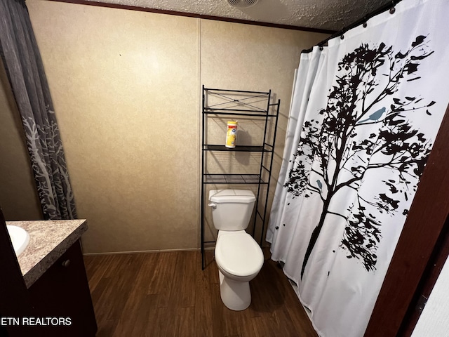 full bath featuring wood finished floors, a shower with shower curtain, toilet, vanity, and visible vents