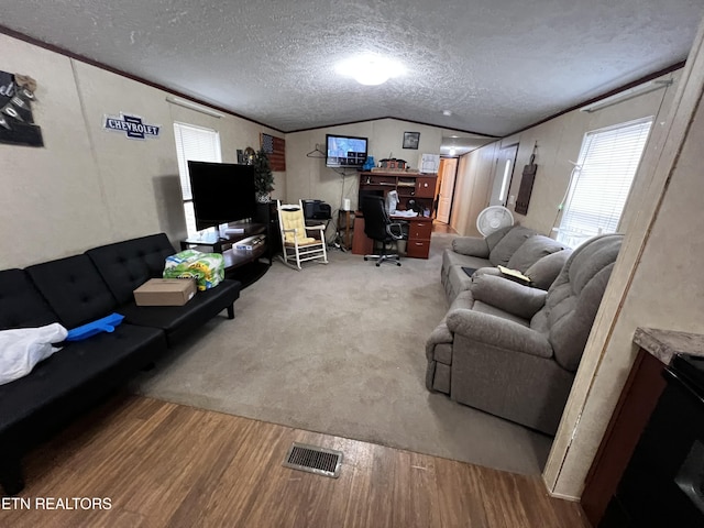 living room featuring a textured ceiling, visible vents, wood finished floors, and lofted ceiling