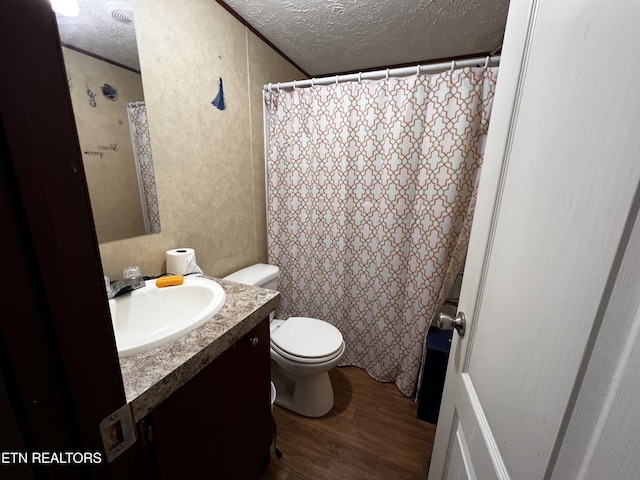 full bath with toilet, vanity, a textured ceiling, and wood finished floors