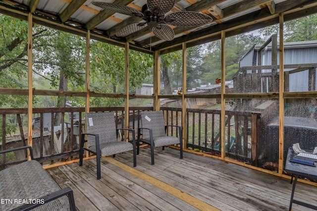 unfurnished sunroom with ceiling fan