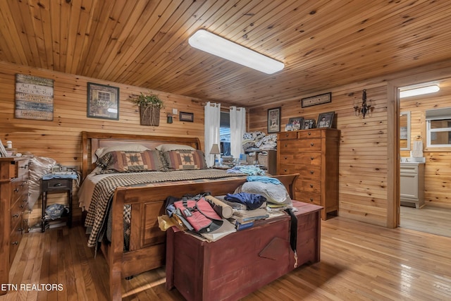 bedroom featuring wooden ceiling, wood walls, and light wood-style floors