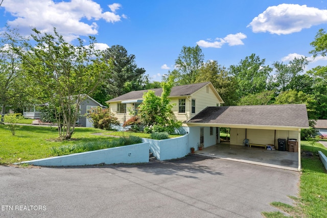 view of front facade featuring a front lawn, aphalt driveway, and an attached carport