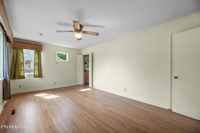 spare room featuring ceiling fan, visible vents, baseboards, and light wood-type flooring