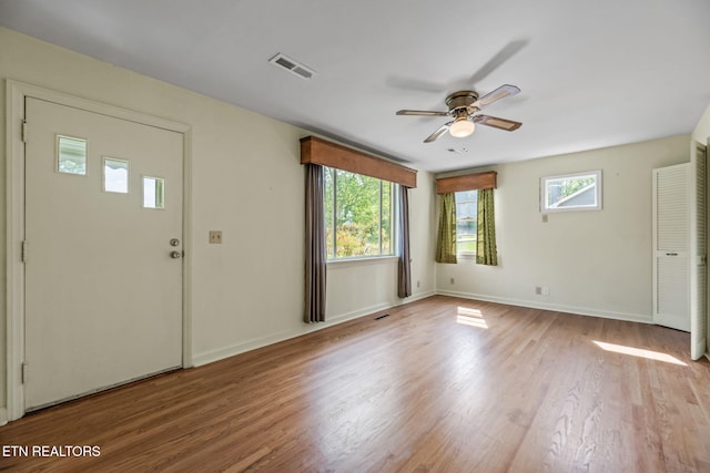foyer with visible vents, a ceiling fan, baseboards, and wood finished floors