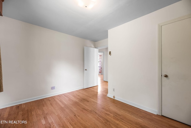unfurnished room with baseboards and wood finished floors