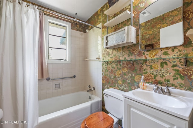 bathroom featuring vanity, toilet, wallpapered walls, and shower / tub combo