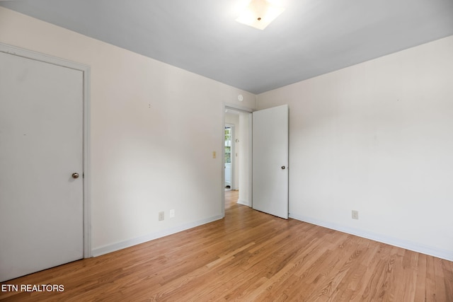 unfurnished bedroom featuring baseboards and light wood-type flooring