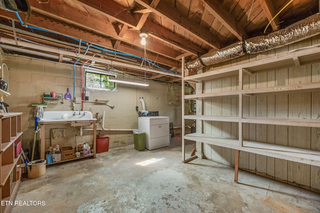 basement with a sink and washing machine and dryer