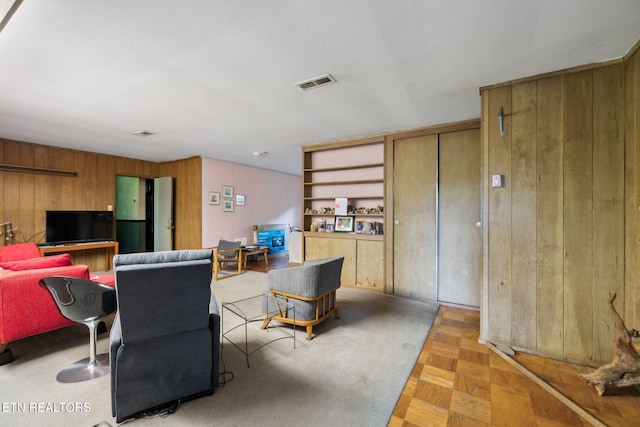 living room with wooden walls and visible vents