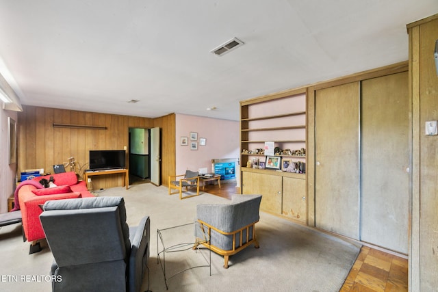 living room featuring wooden walls and visible vents