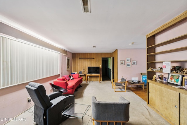 living area with wooden walls and visible vents