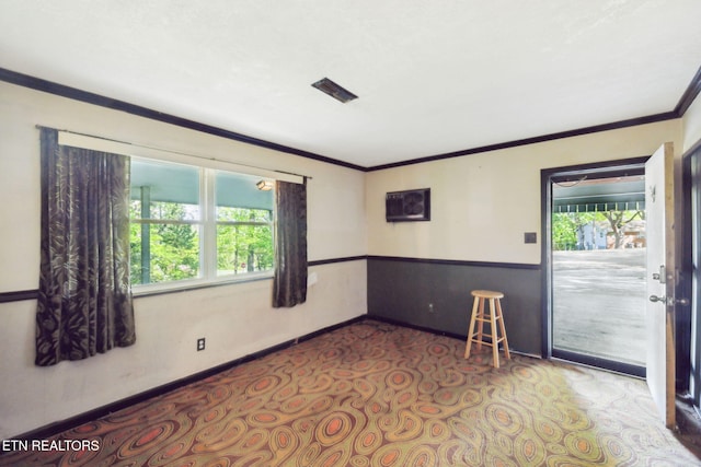 empty room with crown molding, baseboards, and carpet flooring