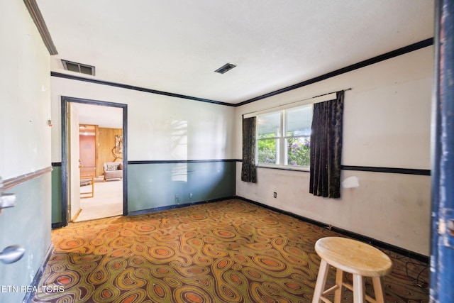 spare room featuring crown molding, baseboards, and visible vents