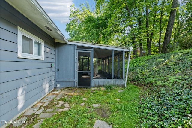 view of side of home featuring a sunroom and board and batten siding