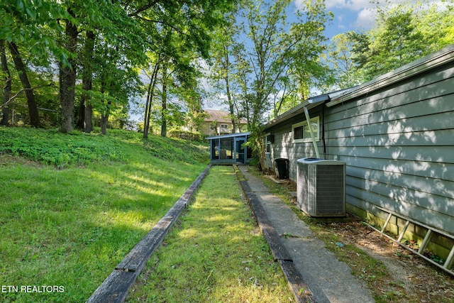 view of yard featuring central AC and a sunroom
