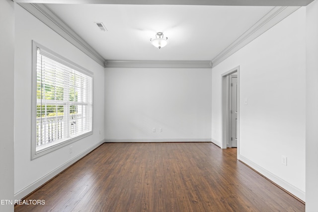 spare room with visible vents, ornamental molding, baseboards, and wood finished floors