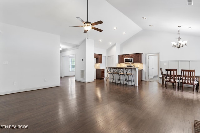 living room with visible vents, dark wood-style flooring, high vaulted ceiling, recessed lighting, and ceiling fan with notable chandelier