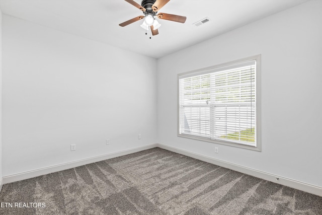 carpeted empty room featuring visible vents, baseboards, and ceiling fan
