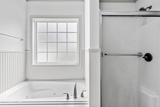 bathroom featuring a jetted tub and a shower stall