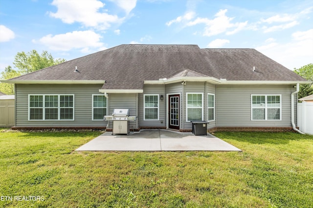 back of house featuring a lawn, a patio area, roof with shingles, and fence