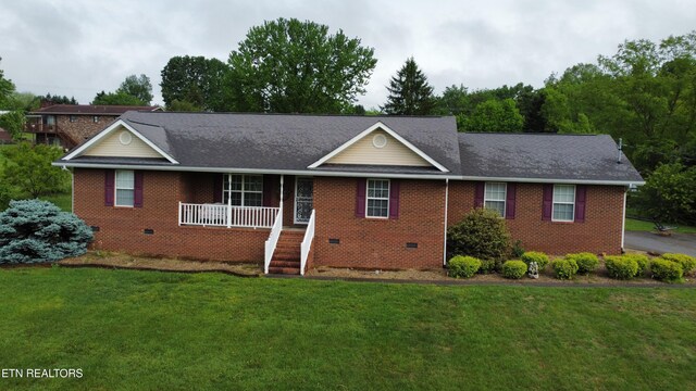 single story home with brick siding, a porch, a front yard, and crawl space