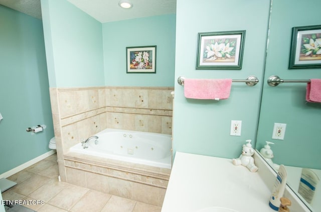 bathroom with a textured ceiling, baseboards, toilet, a jetted tub, and tile patterned flooring