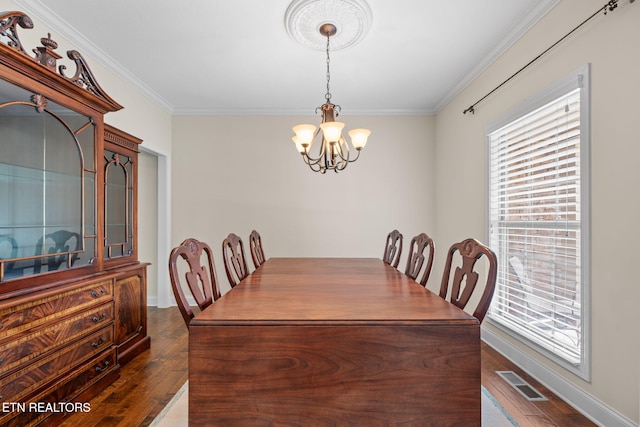 dining space featuring crown molding, visible vents, dark wood-style floors, and a chandelier