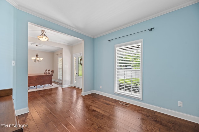 empty room with visible vents, crown molding, baseboards, an inviting chandelier, and dark wood-type flooring