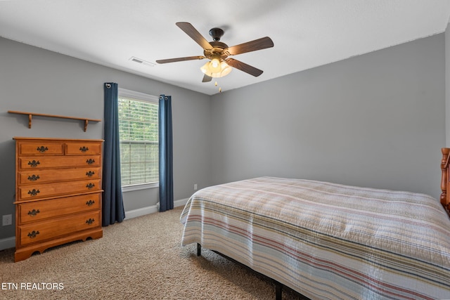 carpeted bedroom featuring baseboards, ceiling fan, and visible vents