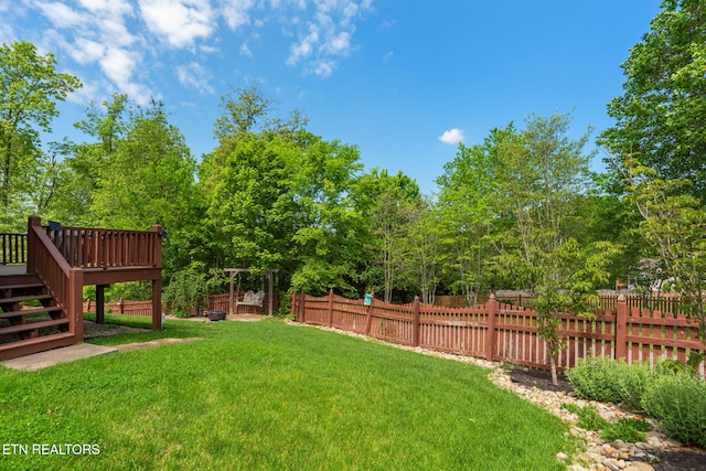view of yard with stairway, a deck, and fence