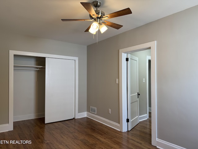 unfurnished bedroom featuring wood finished floors, a closet, visible vents, and baseboards
