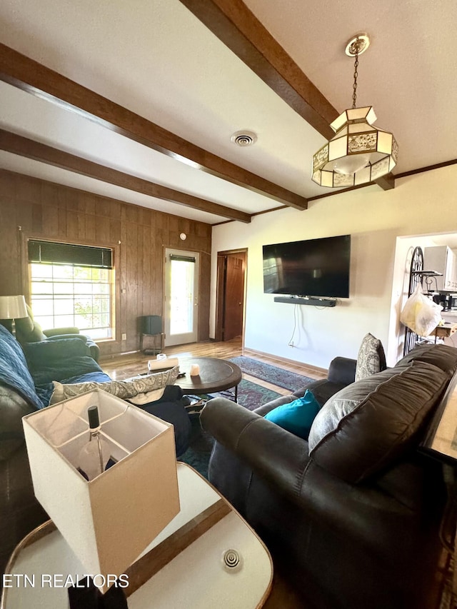 living room featuring visible vents, baseboards, and beamed ceiling